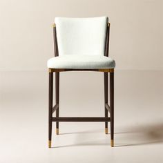 an upholstered bar stool with wooden legs and a white fabric seat padding