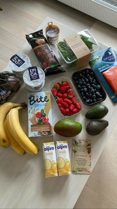 an assortment of fruits, yogurt, and other food items on a table