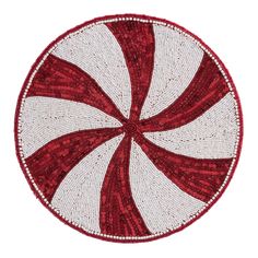 a red and white round rug on top of a table