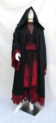 a mannequin dressed in black and red clothing with white hands on it's chest