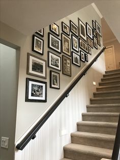 a staircase with pictures on the wall and framed photos above it, along with stairs