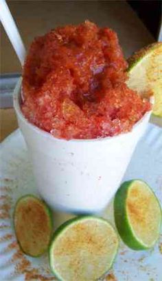 a white bowl filled with food on top of a plate next to sliced limes