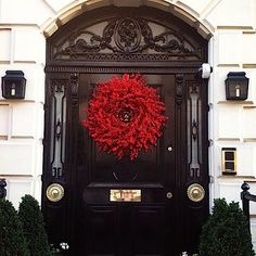 a black door with a red wreath on it