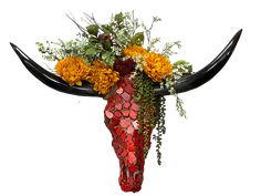 a bull's skull decorated with flowers and greenery