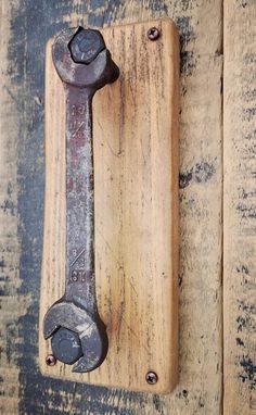 an old wrench hanging on the side of a wooden door