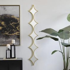 a living room with white walls, black and gold decor and a large painting on the wall