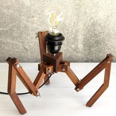 a lamp made out of wood with a light bulb on it's base and two legs