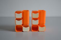 three orange and white containers stacked on top of each other