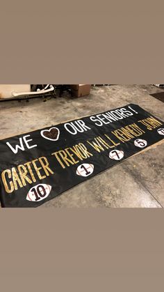 a sign that says we love our school and is on the floor next to other signs