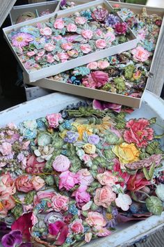 two boxes filled with flowers sitting on top of a wooden table next to each other