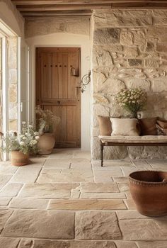 a stone house with potted plants on the porch