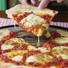 a person taking a slice of pizza from a pan