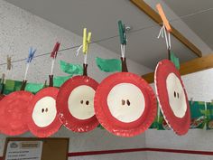 paper plate apples are hanging from the ceiling