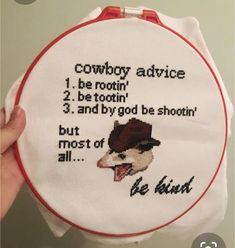 someone is holding up a cross - stitch hoop with the words cowboy advice on it