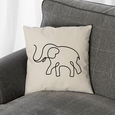 an elephant pillow sitting on top of a gray couch