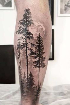 a man's leg with trees and the moon on it