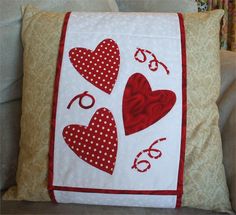 a red and white pillow with hearts on it