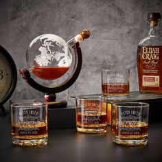 an assortment of whiskeys and glasses sitting on a table with a clock in the background