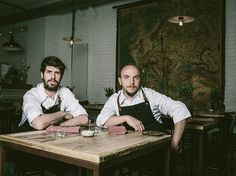 two men sitting at a table in a restaurant