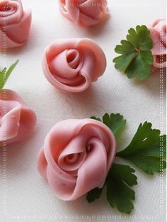 small pink roses with green leaves on a white tablecloth, ready to be cut into flowers