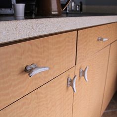 a wooden cabinet with metal handles and knobs on the front, in a kitchen