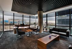 a living room filled with furniture next to large window covered in lots of panoramic windows