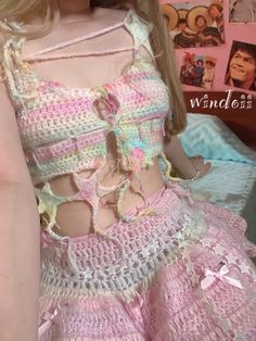 the doll is wearing a pink dress with crocheted details on it's chest