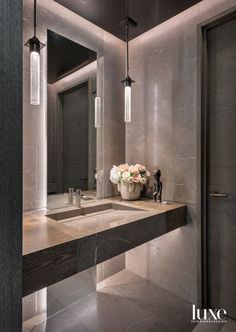 a bathroom with a sink, mirror and lights on the wall next to each other