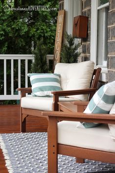 two wooden chairs sitting on top of a porch