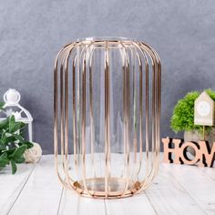 a gold vase sitting on top of a white table next to a potted plant