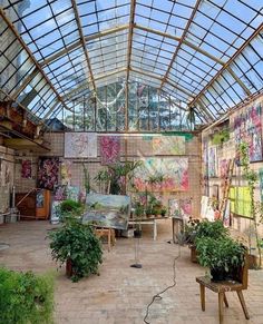 a room filled with lots of plants and paintings