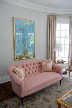 a living room filled with furniture and a painting on the wall