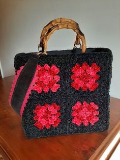 a crocheted handbag sitting on top of a wooden table next to a wall