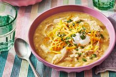 a pink bowl filled with chicken and cheese soup