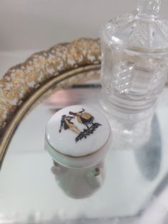 a glass and gold tray with a small white box sitting on it's side