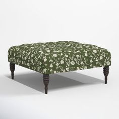 an upholstered footstool with flowers on it