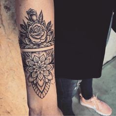 a woman's arm with a flower tattoo on it