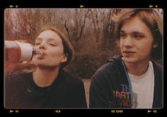 two young people are drinking out of bottles