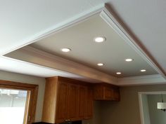 a kitchen with wooden cabinets and white lights