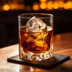 a glass with ice sitting on top of a wooden table