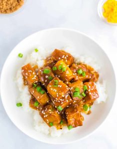 a white plate topped with tofu and rice