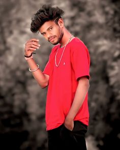 a man in a red shirt and black shorts posing for the camera with his hand on his hip