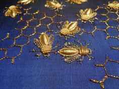 gold embroidered bees on blue fabric