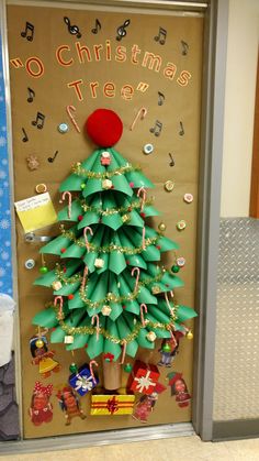 a christmas tree made out of toilet paper and other items is displayed in front of a door