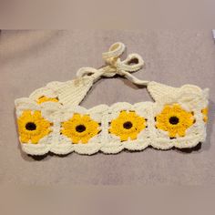 a crocheted headband with yellow and white flowers