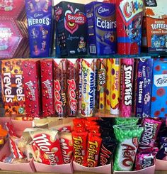 a shelf filled with lots of different flavored candy bars and bags on it's sides