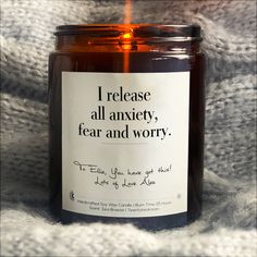 a candle with a label on it sitting in the middle of a blanket that says, i am growing stonger