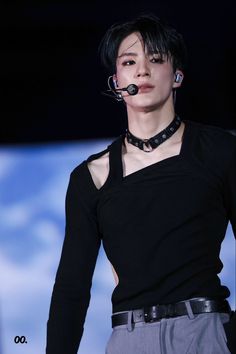 a male model with black hair and piercings on his head wearing a choker