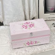 a pink and white box sitting on top of a table next to a window with curtains