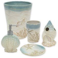 bathroom accessories including soap dispenser, toothbrush holder and seashells